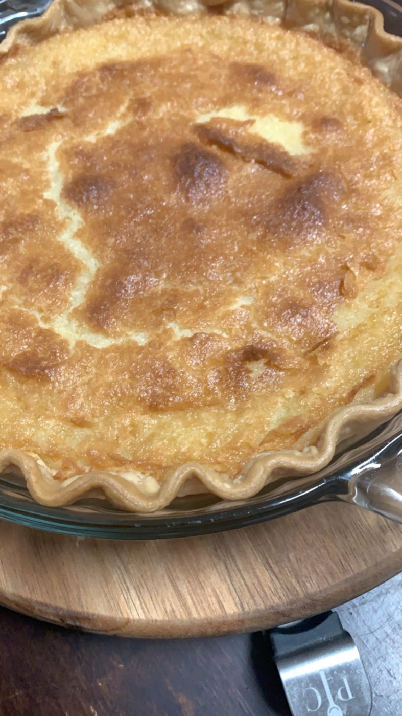Whole buttermilk pie with a crimped crust and golden custard top