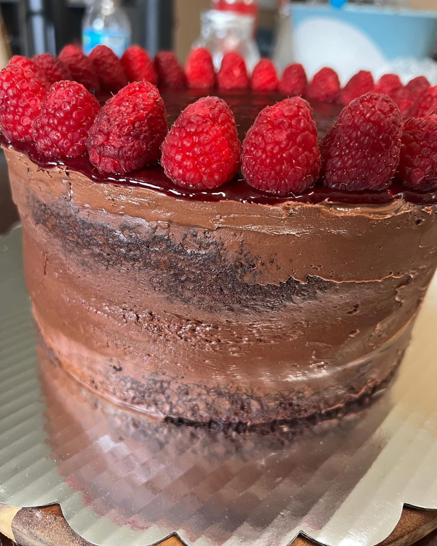 Naked chocolate layer cake crowned with fresh raspberries