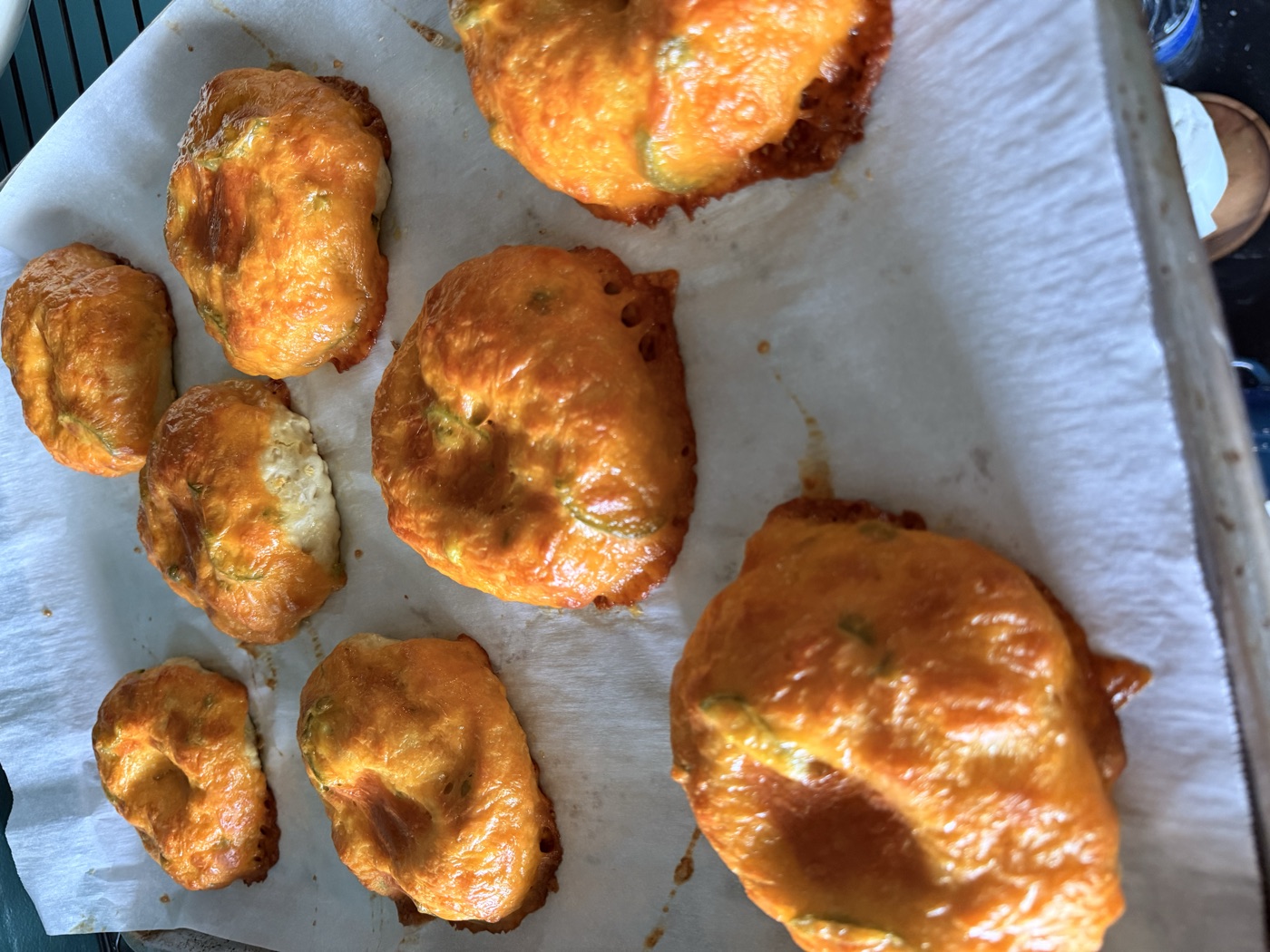 Jalape&ntilde;o cheddar bagels baked deep golden on parchment