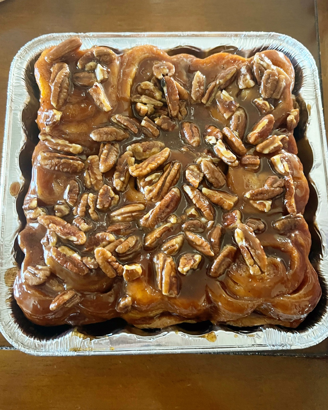 Pan of sticky buns glazed in caramel and covered with pecans